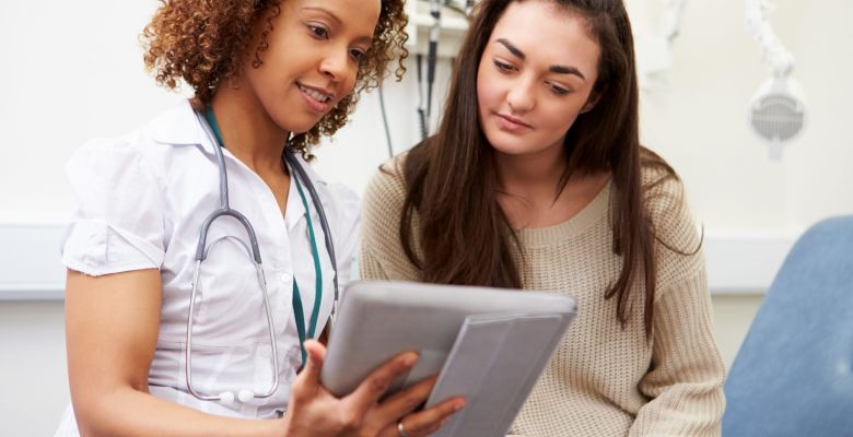 Doctor Showing Patient Test Results On Digital Tablet stock photo